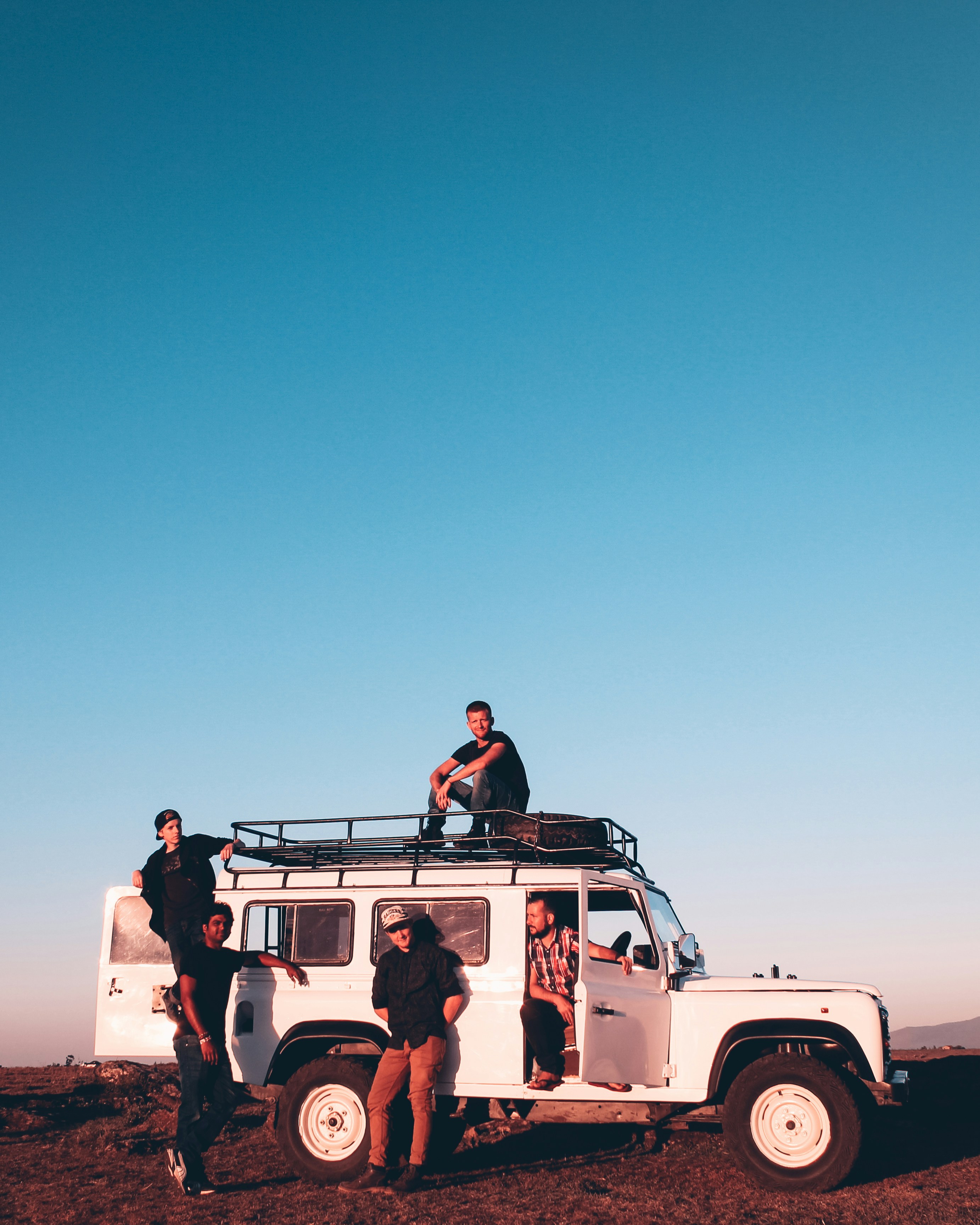 Travellers standing in a safari vehicle on the open plains